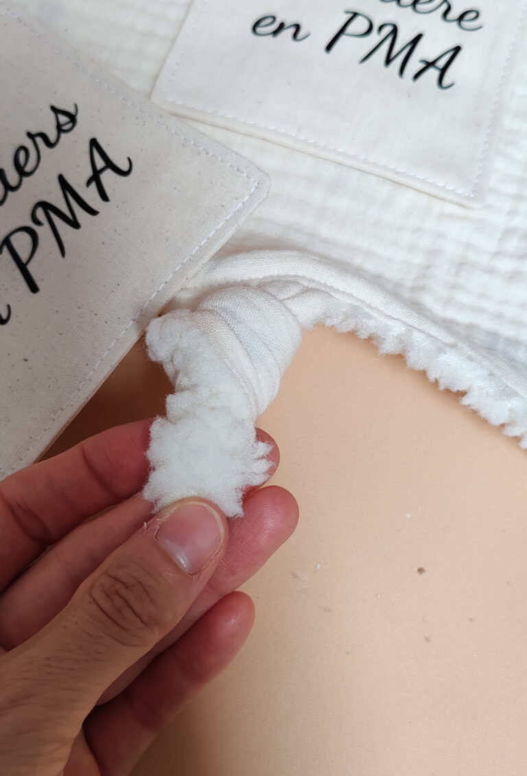 Détail d’un doudou étapes en double gaze avec sa carte « Guerrière en PMA »